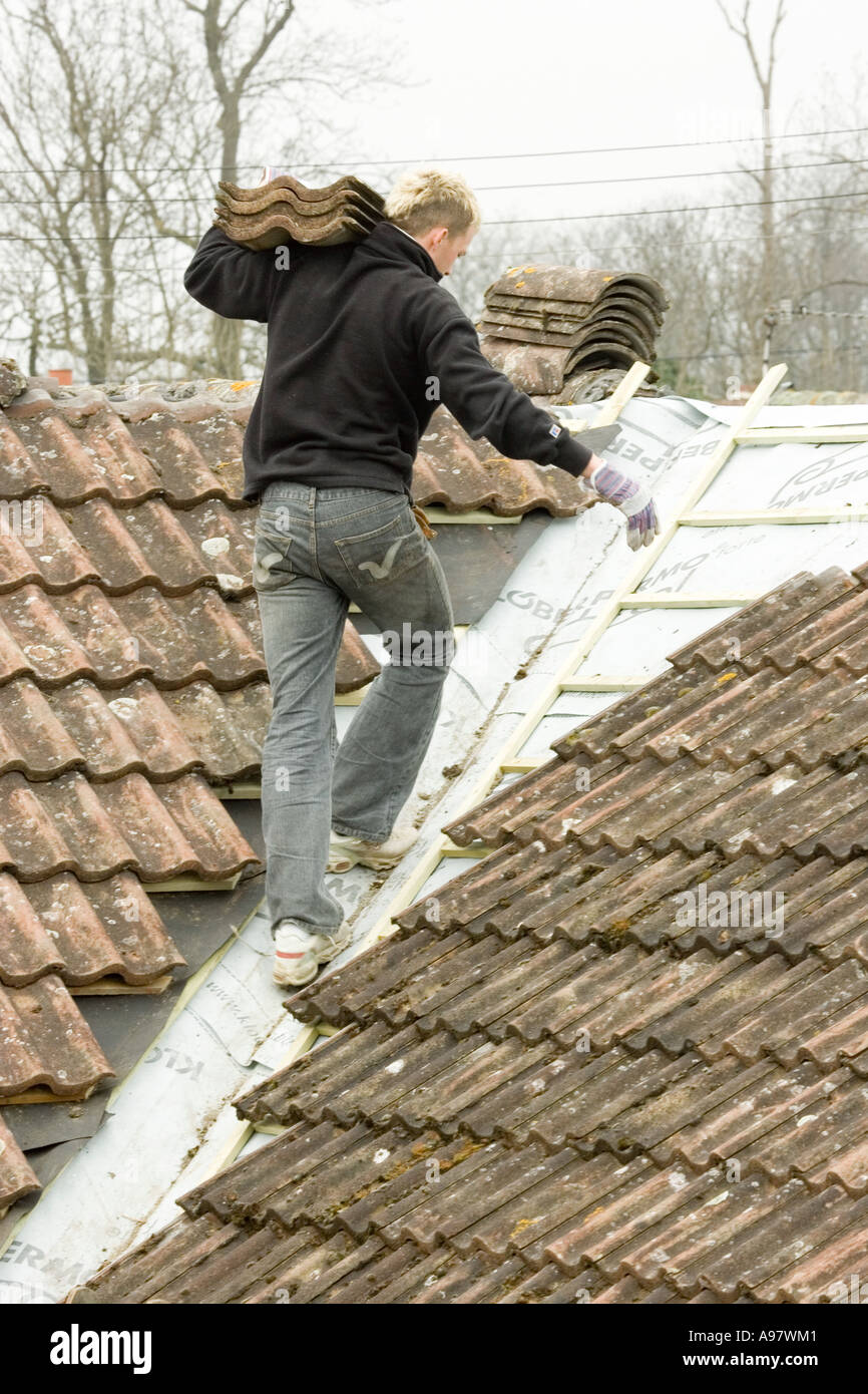 ein Bauherr passende Fliesen auf einem Dach einer Heim-Erweiterung Stockfoto