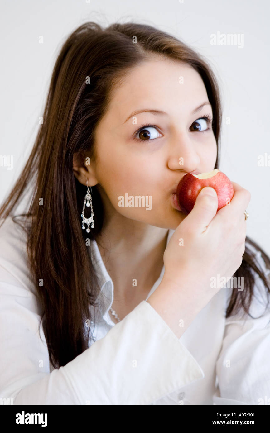 Junge hübsche Mädchen nimmt Abite aus einem Apfel Stockfoto