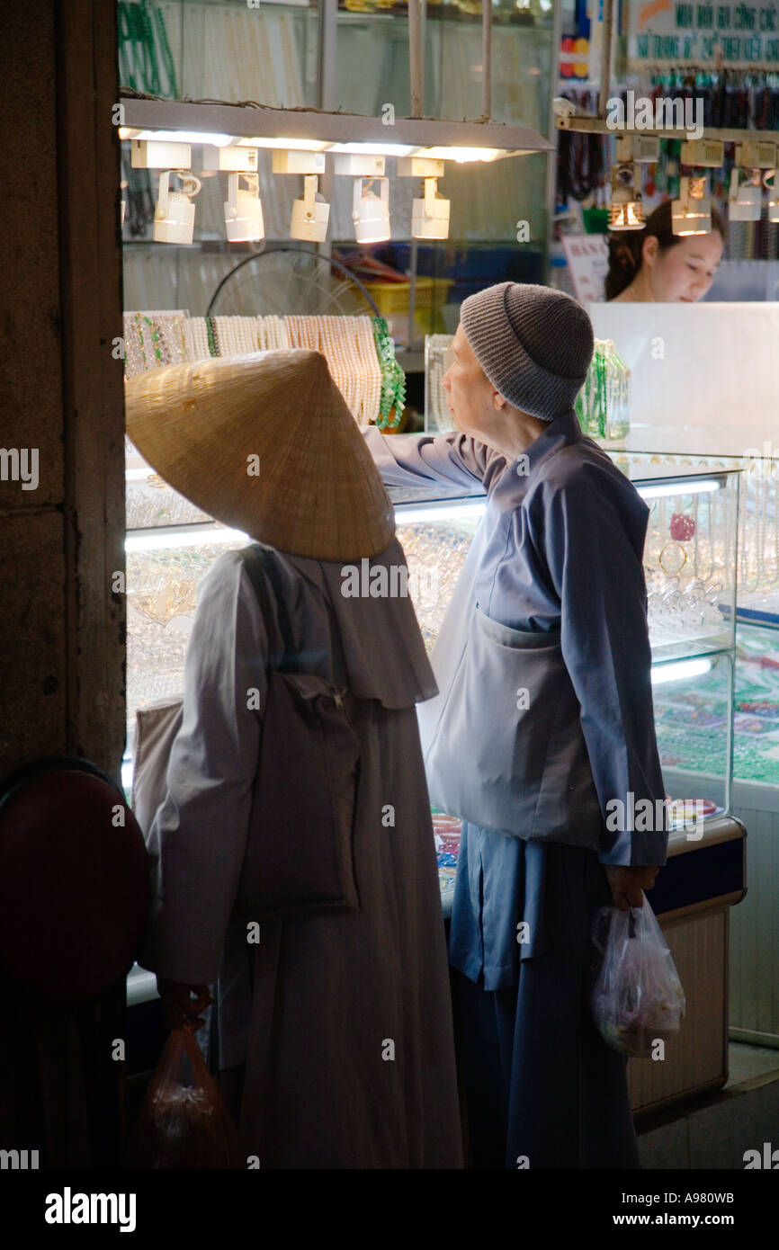 Nonne in konischen Hut und eine alte Frau in Strumpf Hut Einkaufen in Ho-Chi-Minh-Stadt (Saigon), Vietnam Stockfoto