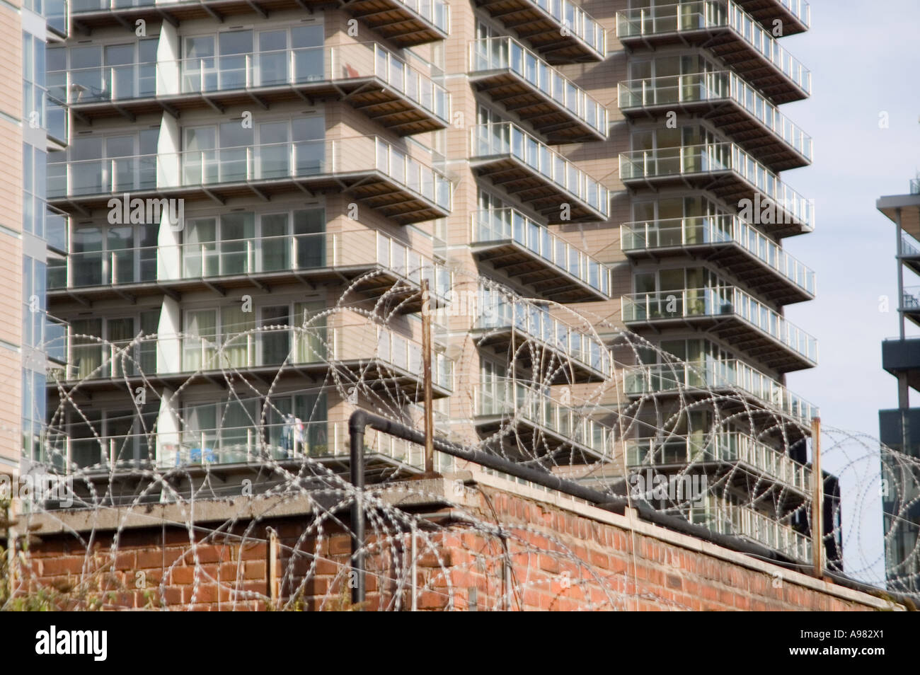 Neue Apartments im Stadtzentrum von Manchester mit Mauer und Stacheldraht-Zäune Stockfoto