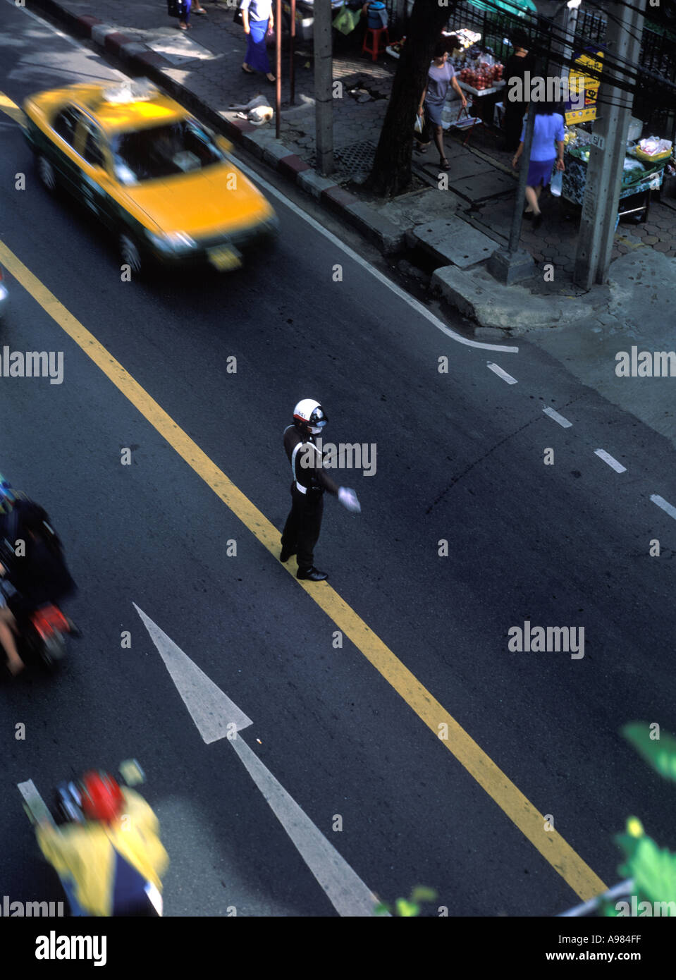 Bangkok Verkehrspolizei regelt den Verkehr wie Verkehr vorbei verwischt durch die Geschwindigkeit in der Innenstadt von Bangkok, Thailand bewegt Stockfoto