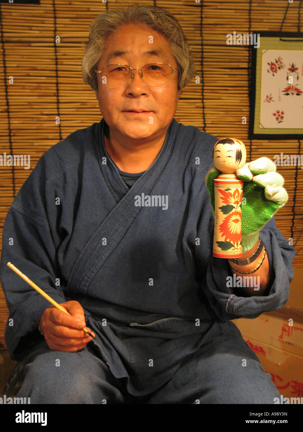 Handwerker und seine Kokeshi Puppe Stockfoto