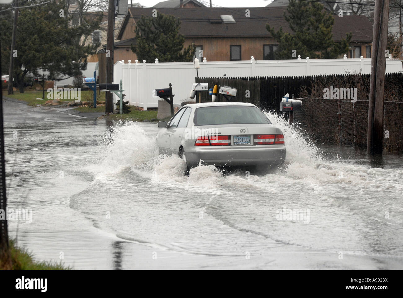 Ein Auto fährt durch die überfluteten Straßen bei einem massiven Frühling noch Ostern Sturm Stockfoto