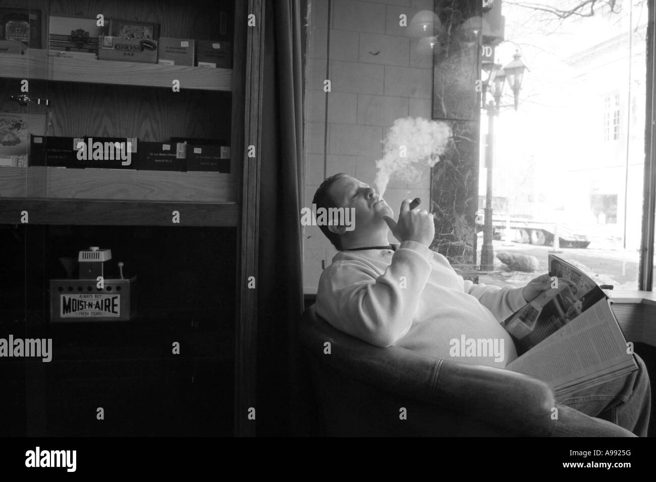 Ein Mann raucht eine Zigarre in eine Zigarrenlounge shop Stockfoto