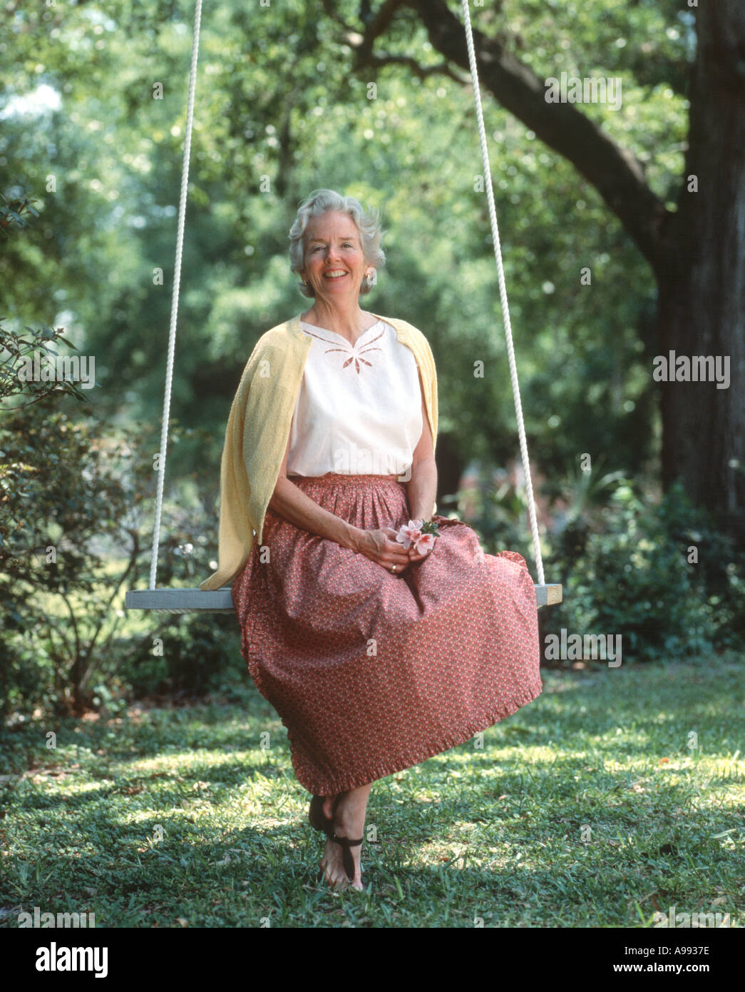 Reife Frau entspannende Baum im Gange Stockfoto
