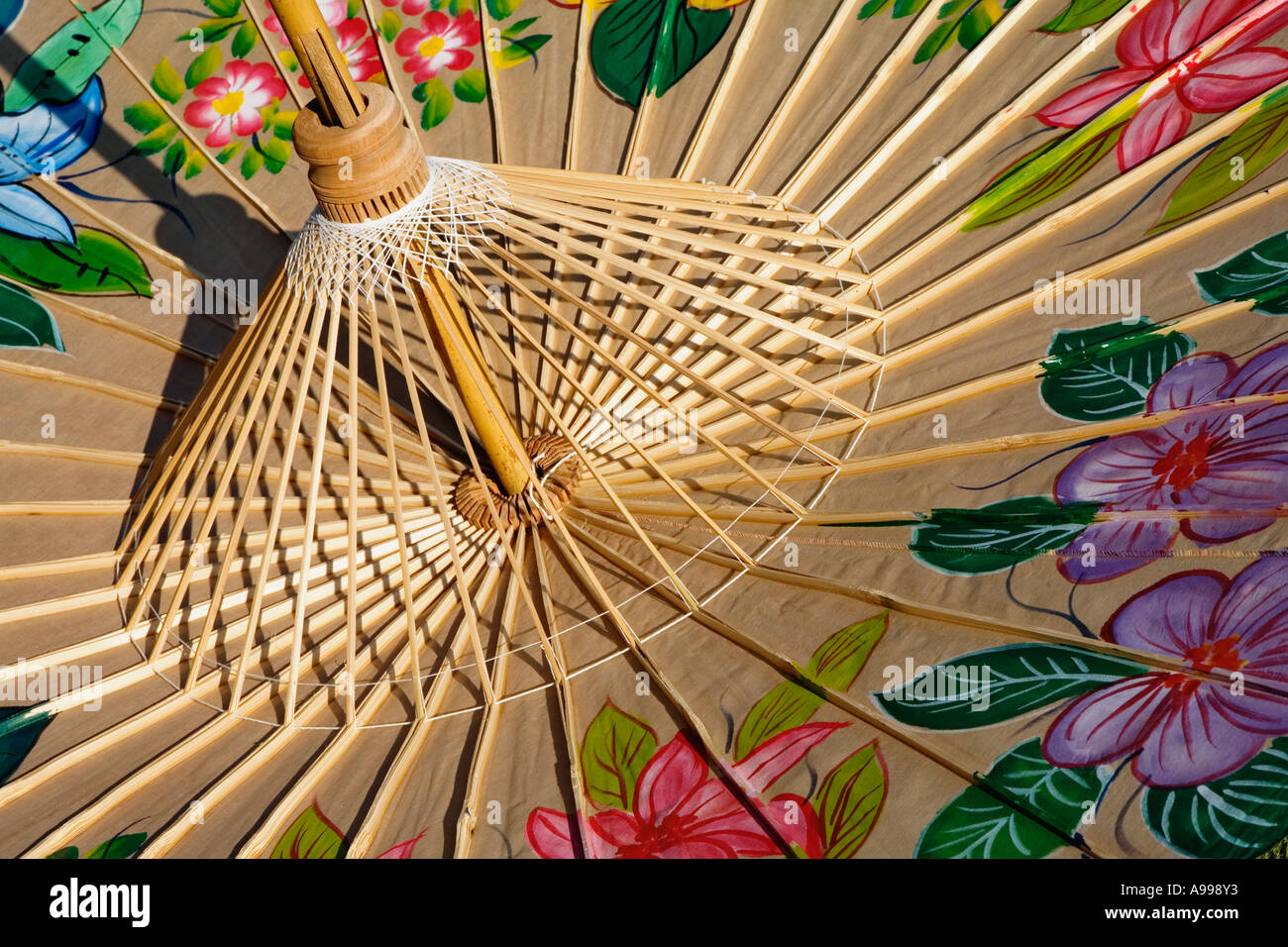 Die Unterseite des ein Baumwolle-Regenschirm mit bunt gemalten Blumen zeigt des Bambus Rippen handgefertigt im Umbrella Making Zentrum Stockfoto