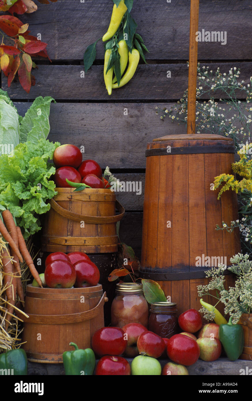 Geernteten Erzeugnisse, antikes Butterfass und Küchencontainer durch alte Scheune Wand in ein Outdoor-Display der Gemeinschaft Bauernmarkt Stockfoto