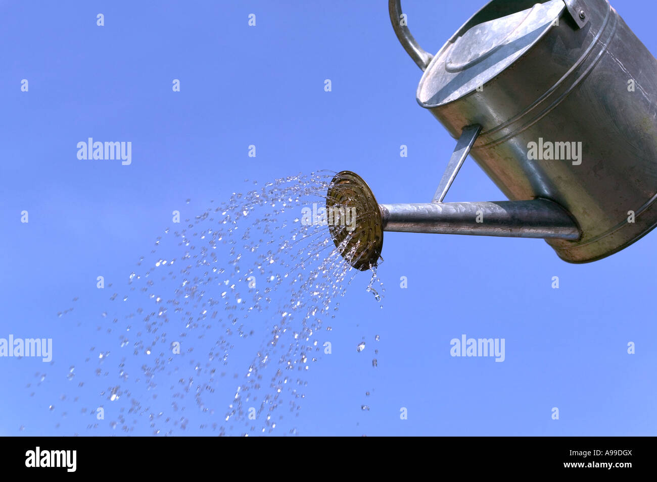 Wasser aus der Gießkanne gießen kann vor blauem Himmel Stockfoto