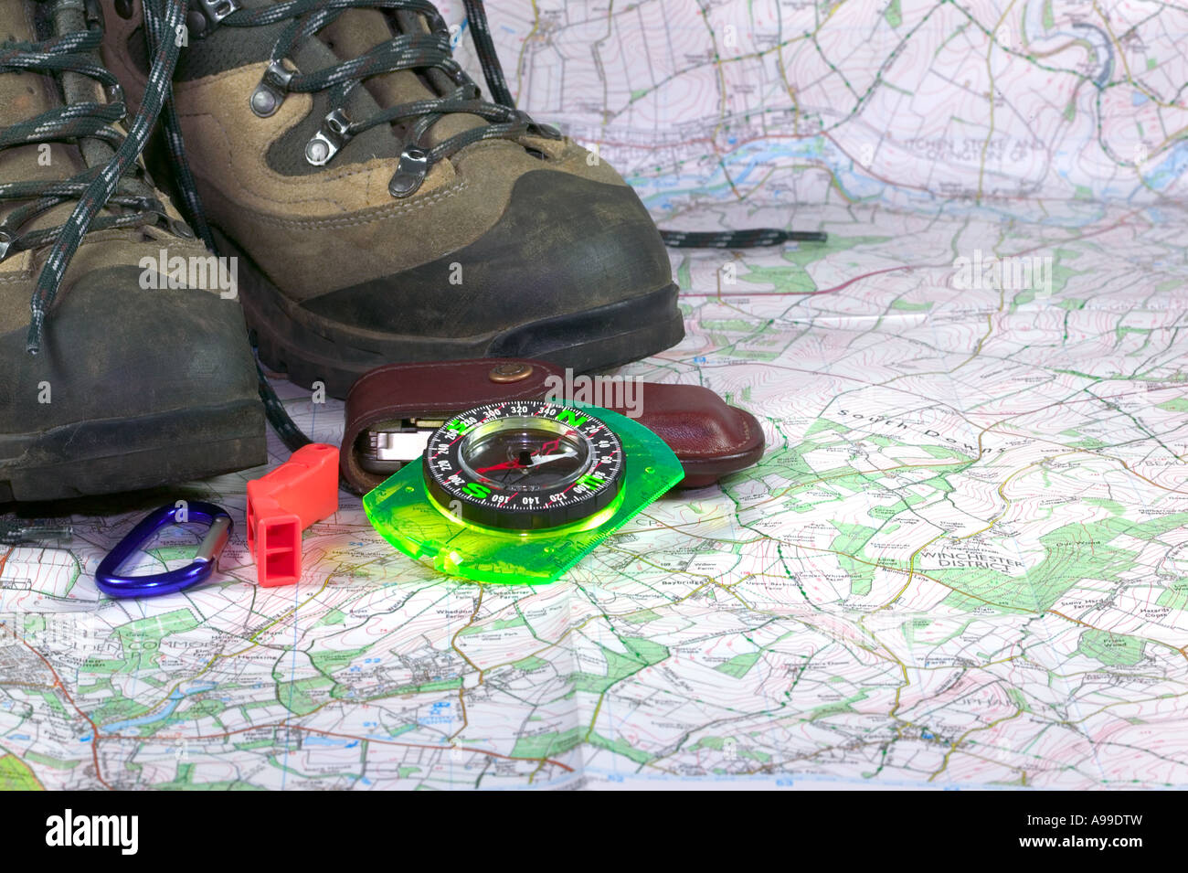 Wanderschuhe, Kompass und Zubehör auf einem Kartenhintergrund Stockfoto