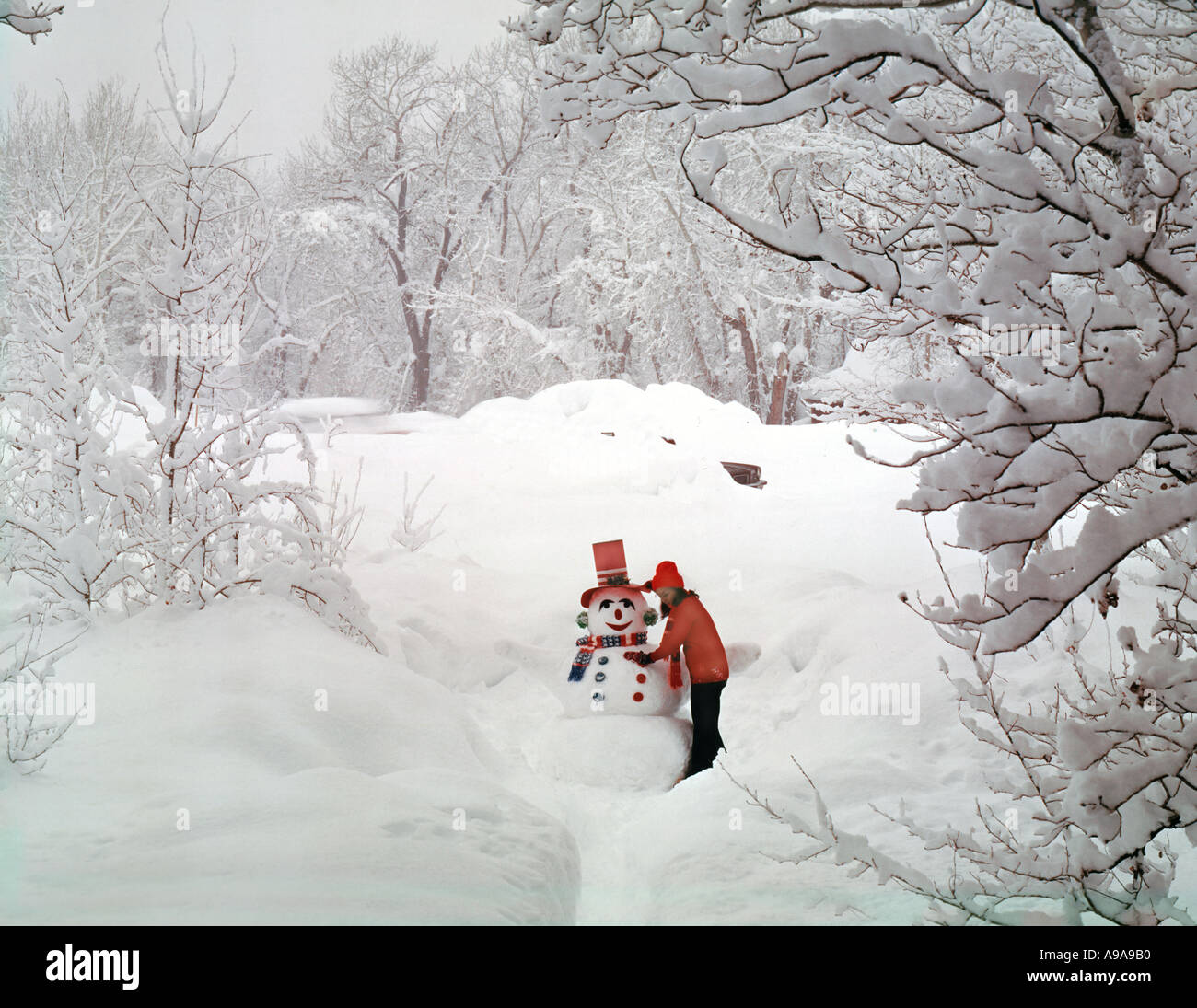 DEKORIEREN EINEN SCHNEEMANN IN EINER VERSCHNEITEN SZENE Stockfoto
