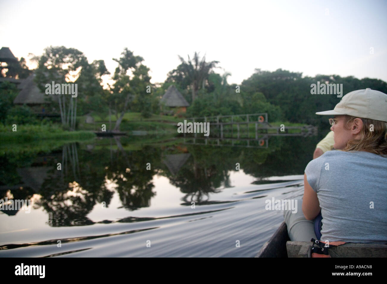 Eine Einbaum Kanu mit Touristen nähert sich das Napo Wildlife Centre über See Anangucocha, Equador Stockfoto