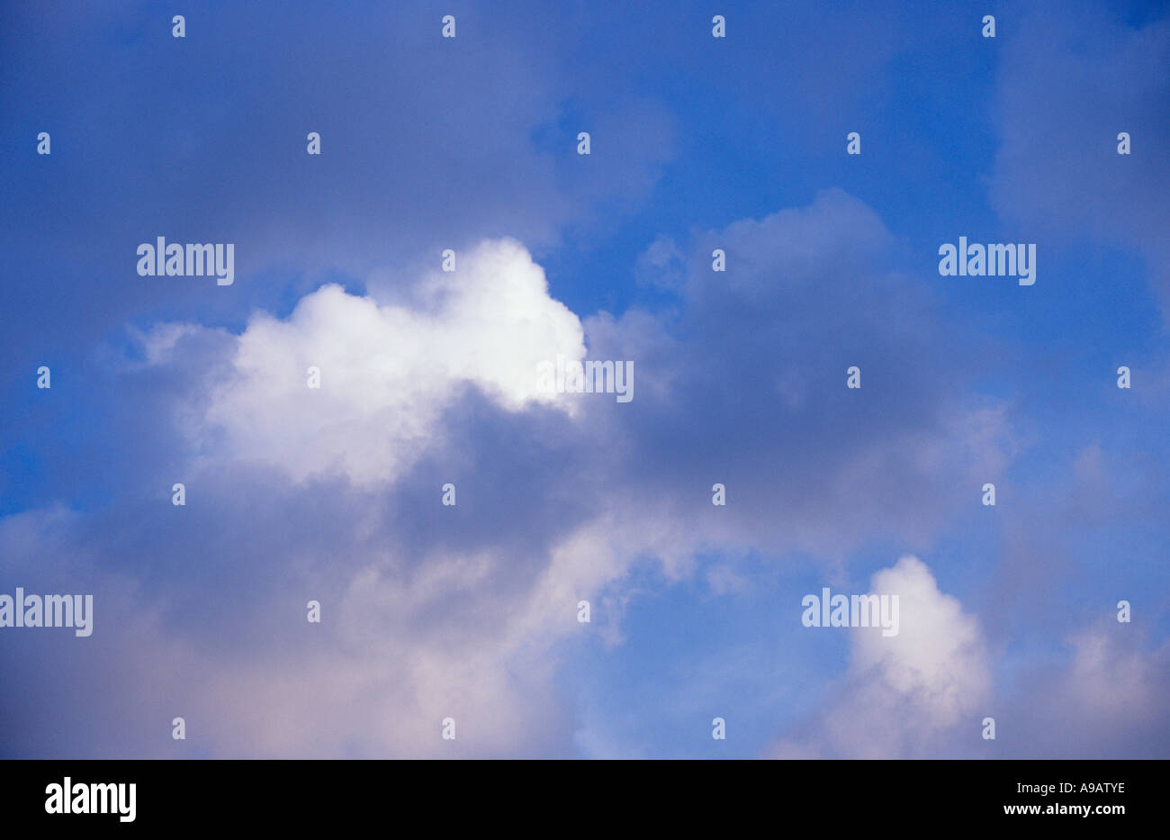 Verstreute weiße und graue Cumulus-Wolken sammeln oder Dispergieren gegen Flecken von blauen Himmel Stockfoto