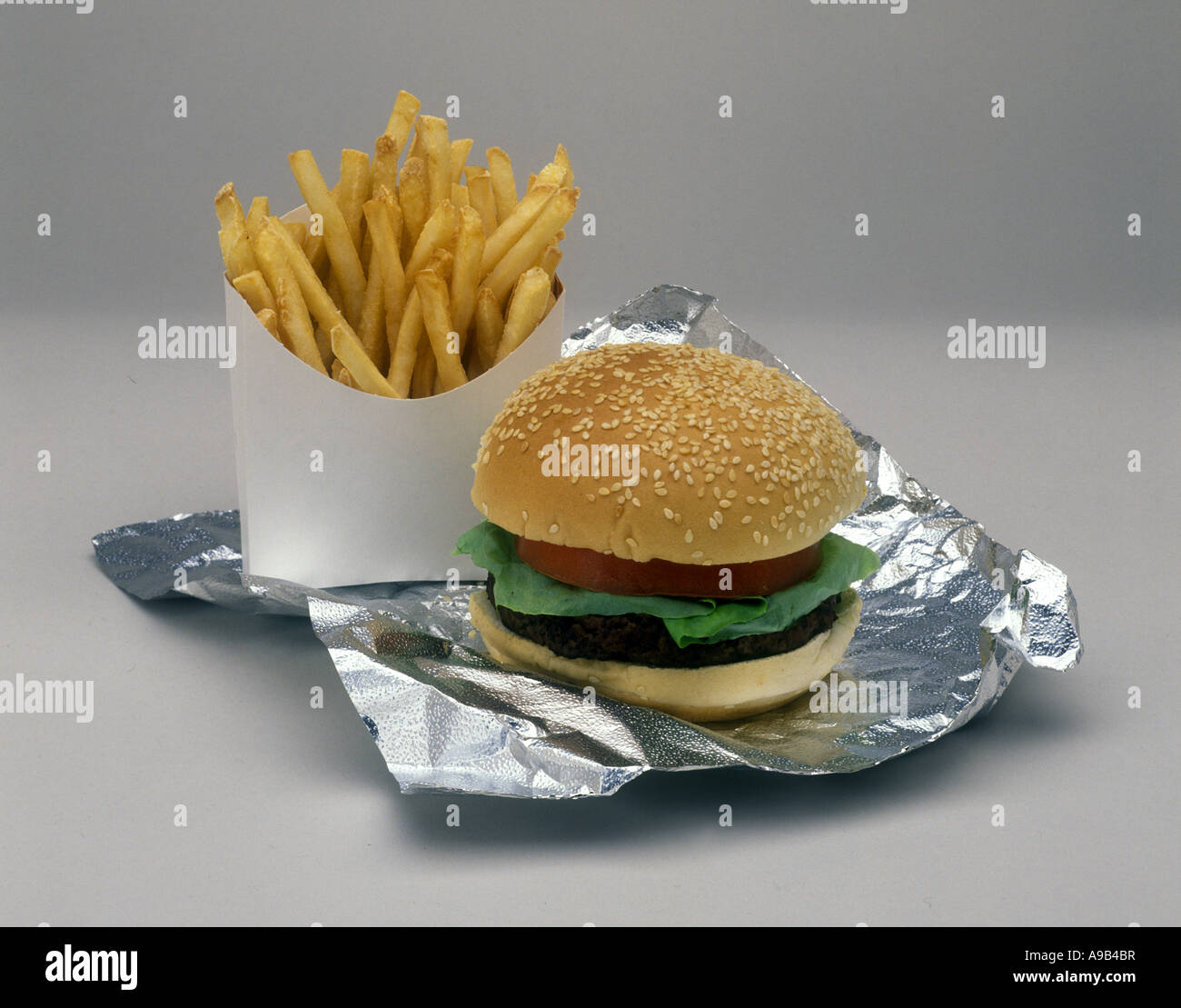 HAMBURGER MIT POMMES FRITES AUF WEIßEM HINTERGRUND Stockfoto