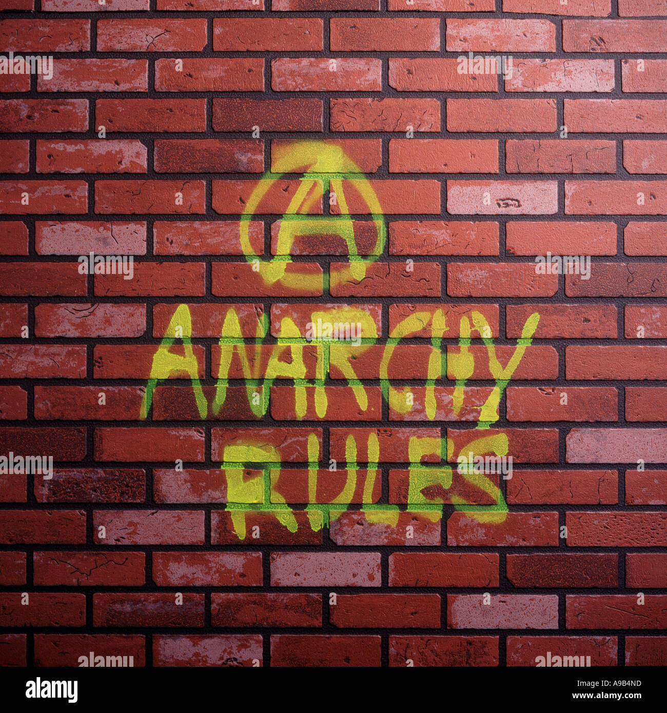 Anarchie-Regeln in gelber Farbe auf Ziegelwand gespritzt Stockfoto