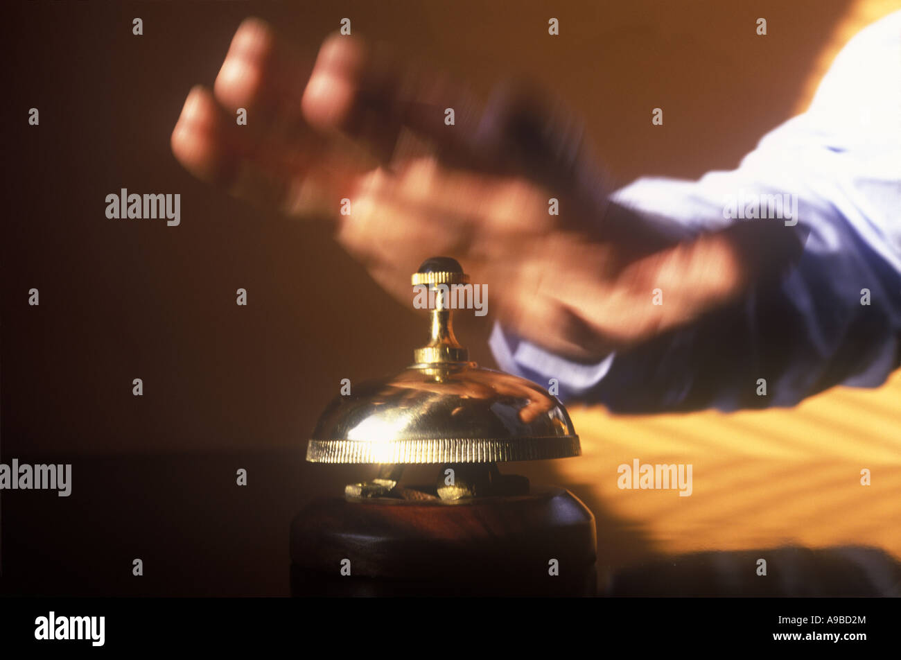MANS HAND HITS HOTEL DESK SERVICE BELL Stockfoto