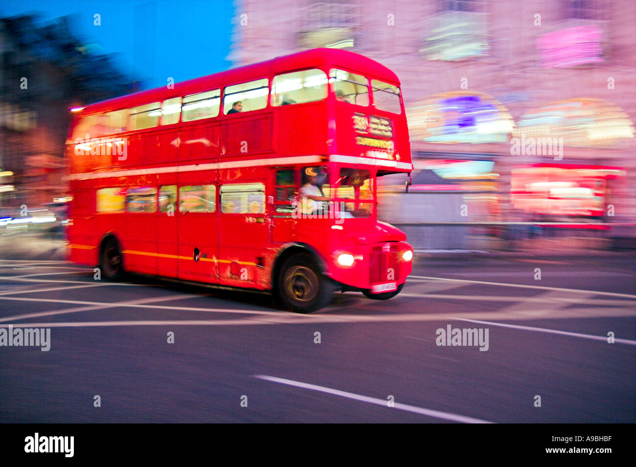 Bewegungsunschärfe von einem roten Doppeldeckerbus Routemaster nachts in London England Stockfoto