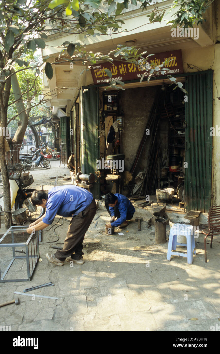 Metallarbeiter auf einem Bürgersteig-Workshop in Lo Ren St, Altstadt in Hanoi, Vietnam Stockfoto