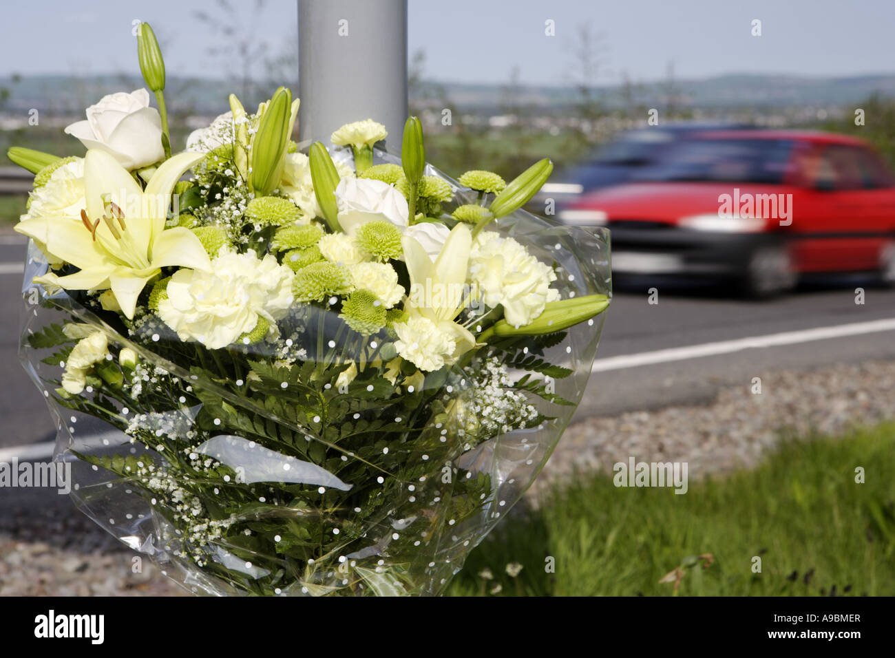 Tod auf den Straßen Auto beschleunigt vorbei ein floral Tribute Kennzeichnung der Stelle von einem tödlichen Verkehrsunfall Stockfoto