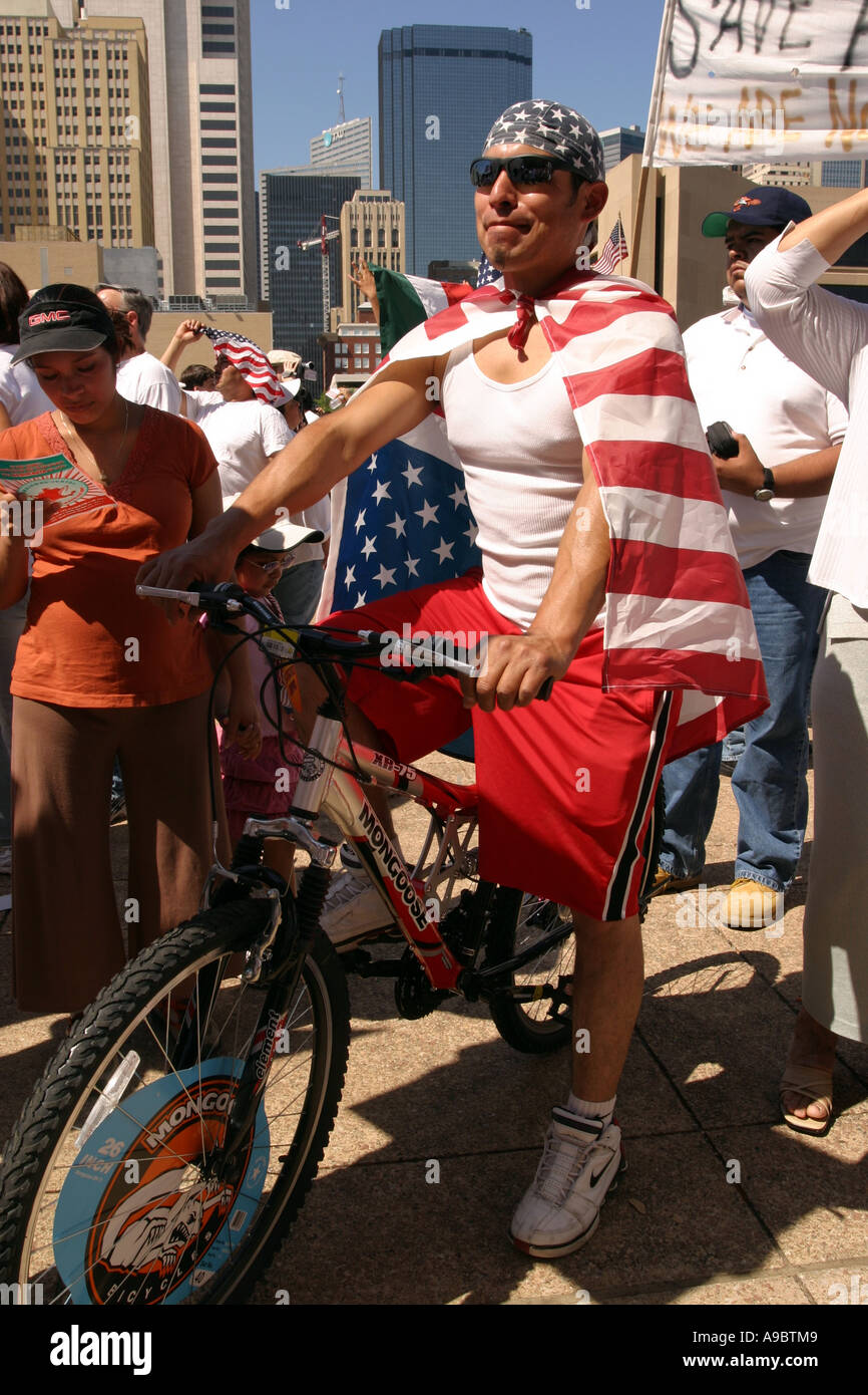 American Hispanic Mann auf einem Fahrrad, amerikanische Flagge tragen. Einwanderung-Rallye, Dallas, Texas, USA Stockfoto