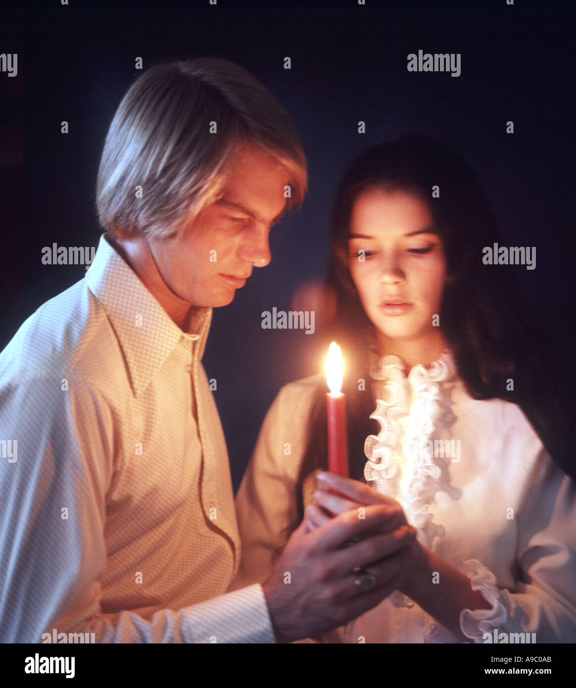 romantische junges Paar, die Erneuerung der Gelübde bei Kerzenschein Stockfoto