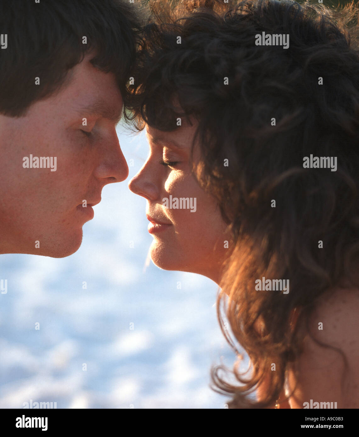 junges Paar mit Köpfen zusammen am Strand liegen Stockfoto
