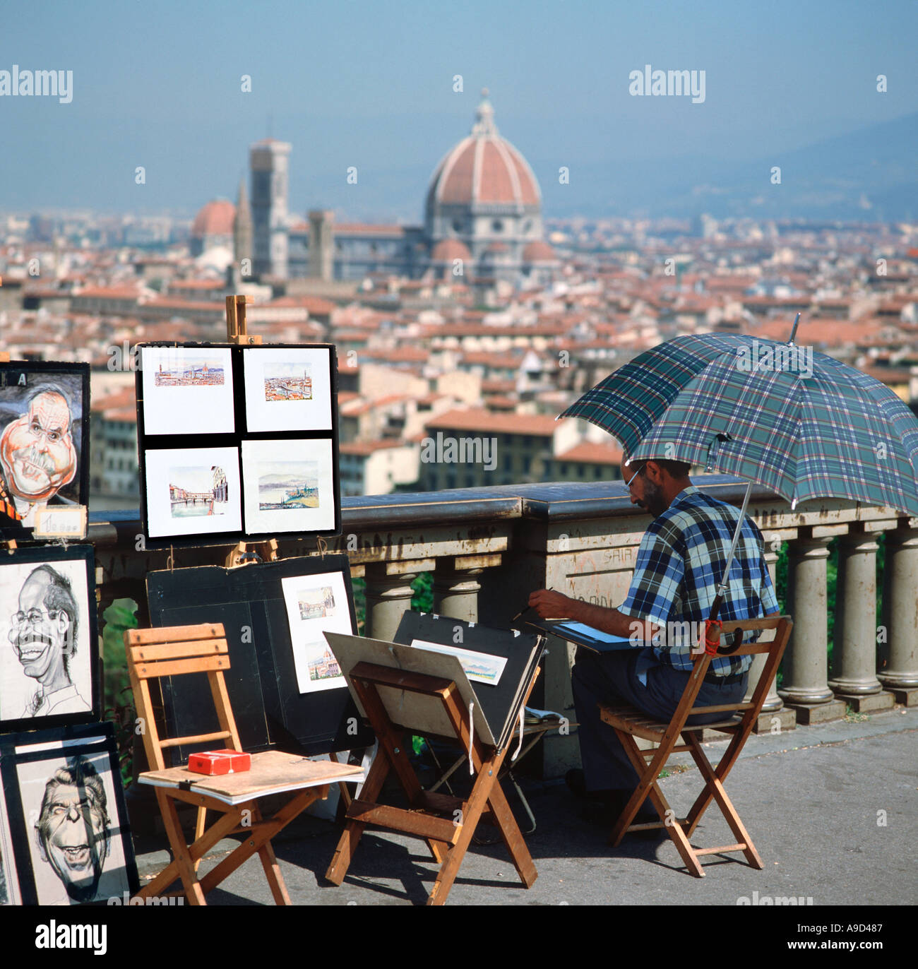 Ein Künstler in Piazzale Michelangelo mit Blick auf den Dom und Altstadt hinter Florenz, Toskana, Italien Stockfoto