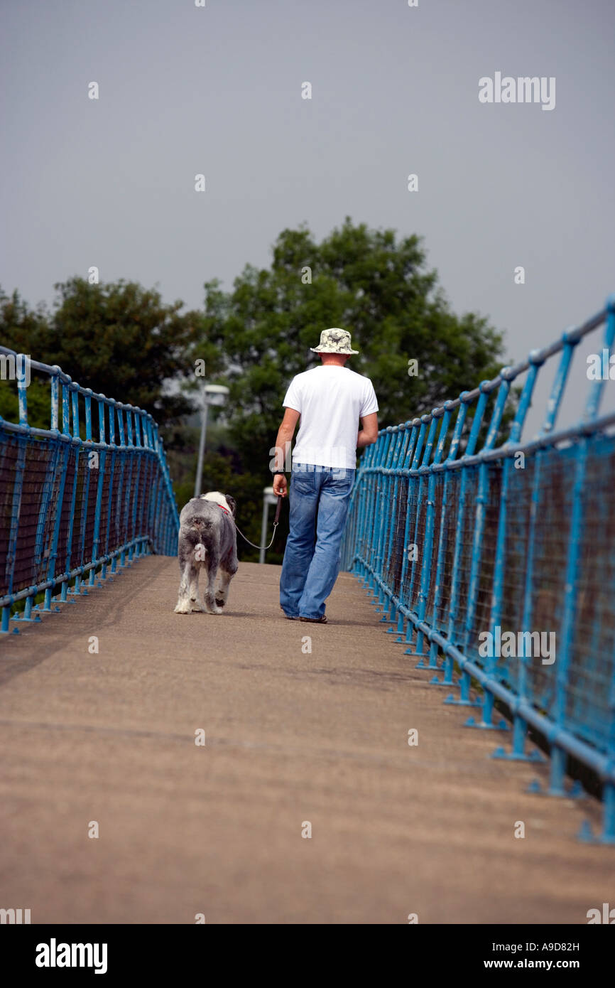 Mann seinen Hund über eine Brücke zu Fuß Stockfoto