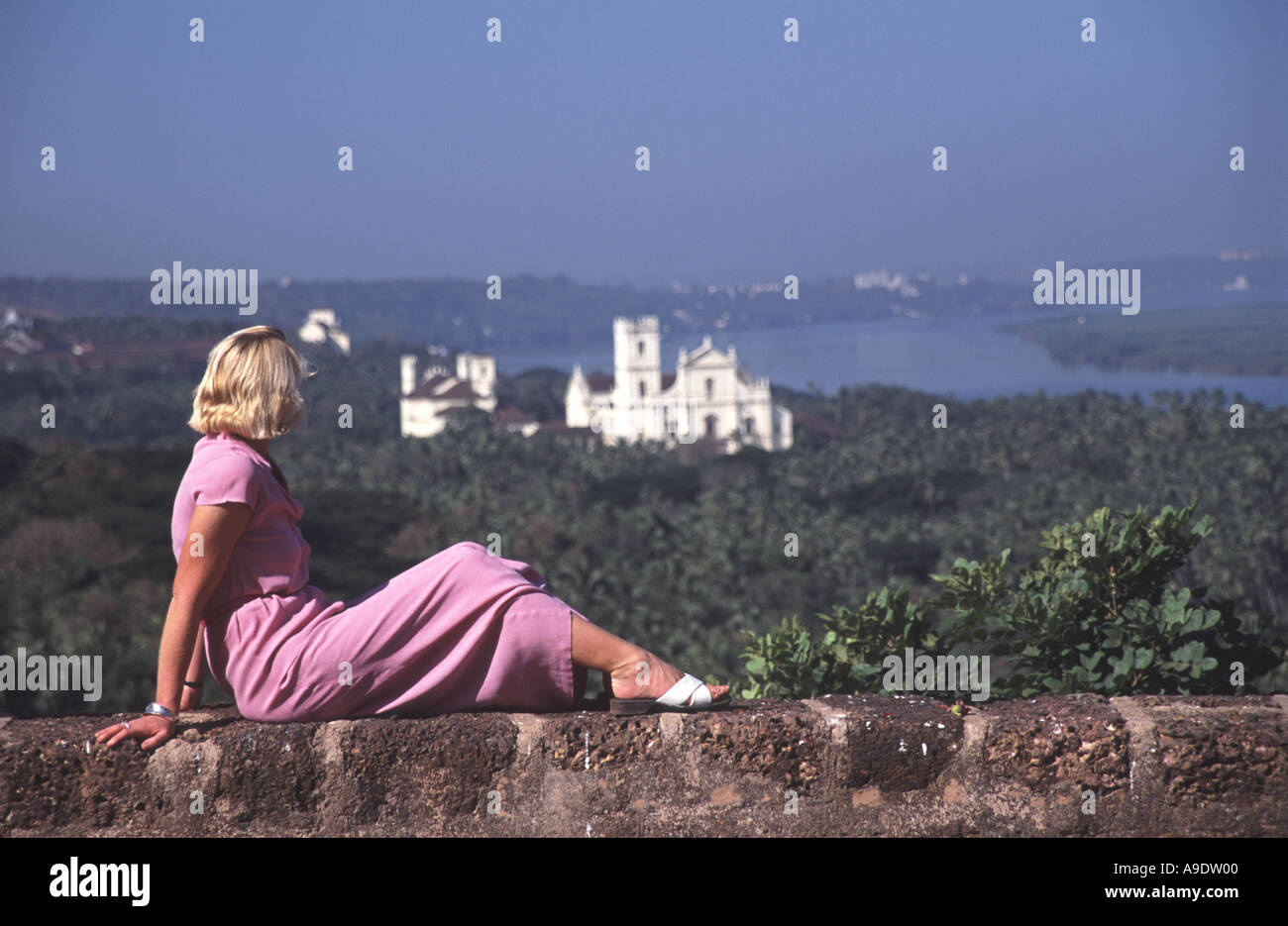 GOA, INDIEN. Eine junge Frau, Blick auf Old Goa in Richtung des Flusses Mandovi aus der Liebfrauenkirche des Berges. Stockfoto
