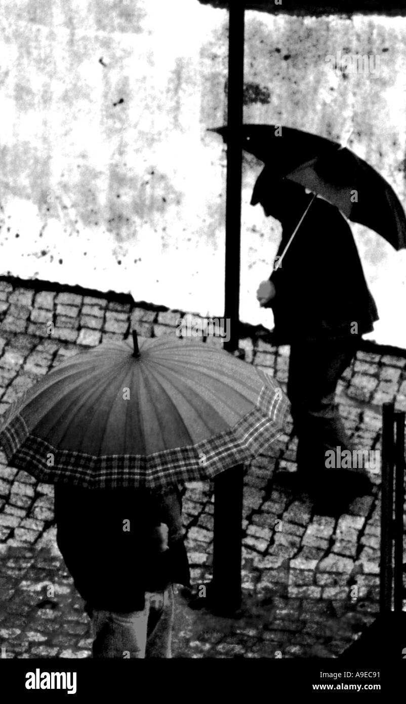 Männer im Regen mit Sonnenschirmen Monchique Portugal Stockfoto