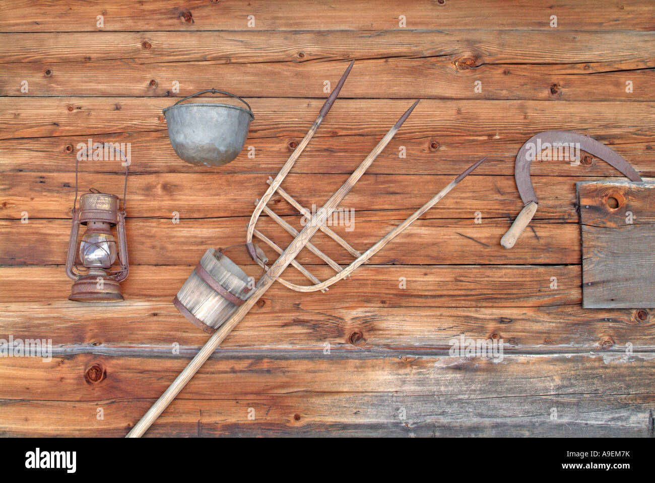 Verschiedene landwirtschaftliche Geräte an der Wand des alpinen Holzhütte Stockfoto