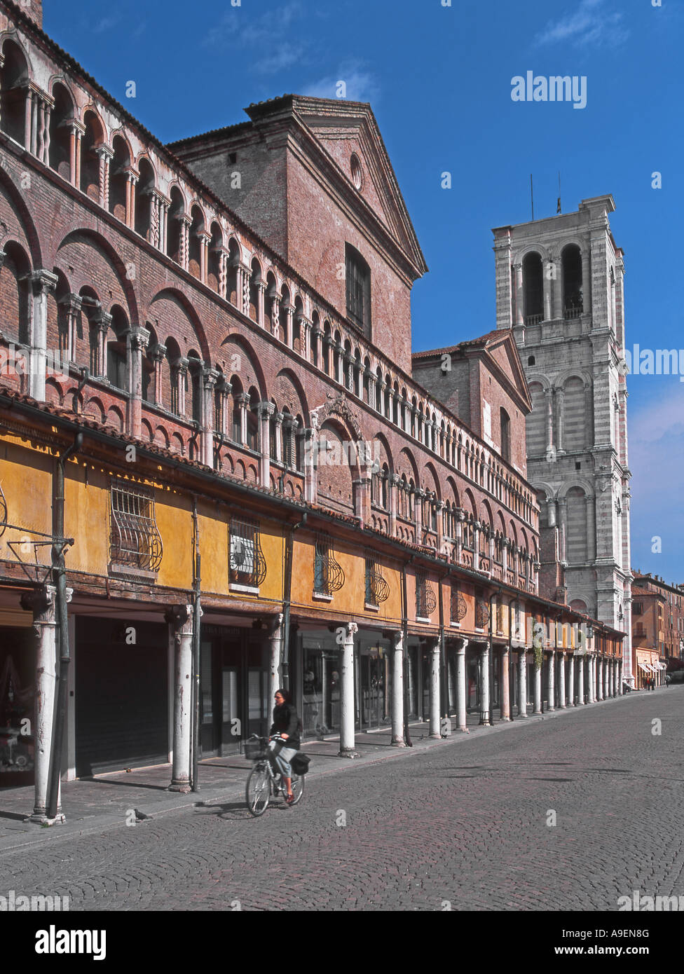 Ferrara, Emilia Romagna, Italien. Piazza Trento Trieste. Arkaden Südseite des Doms. Radrennfahrer Stockfoto