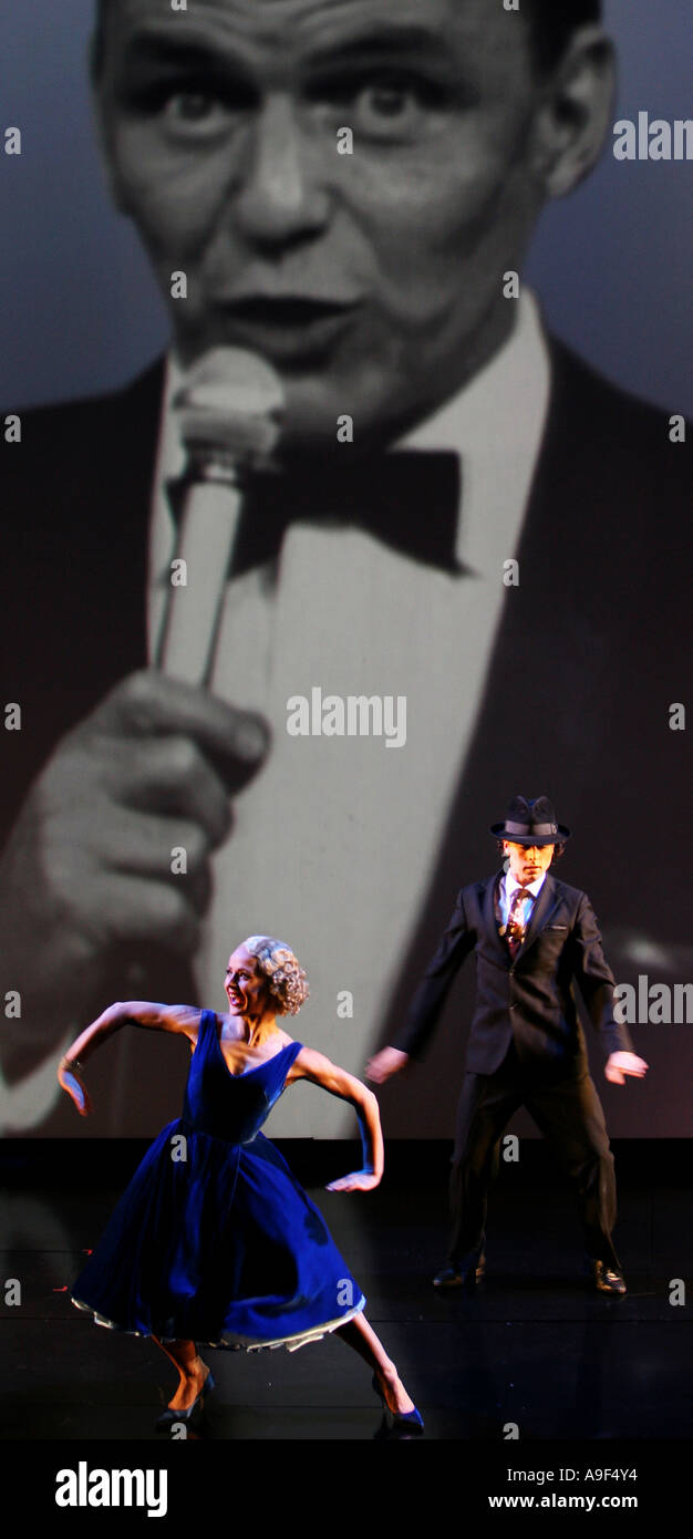 Zwei Tänzer vor einem riesigen Bildschirm mit Aufnahmen von Frank Sinatra singen im London Palladium, London, März 2006 Stockfoto