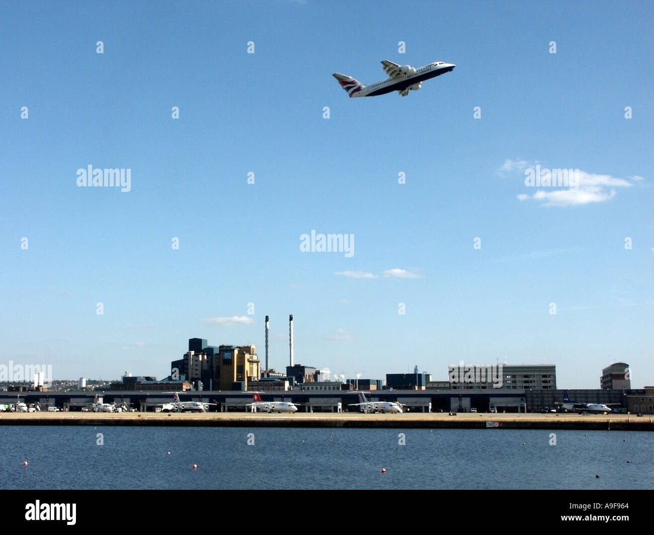 Flugzeug, das vom London City Airport über die Flughafengebäude und Tate an Lyle Sugar Factory startet und Flugzeuge auf Parkplätzen unter Silvertown UK steht Stockfoto