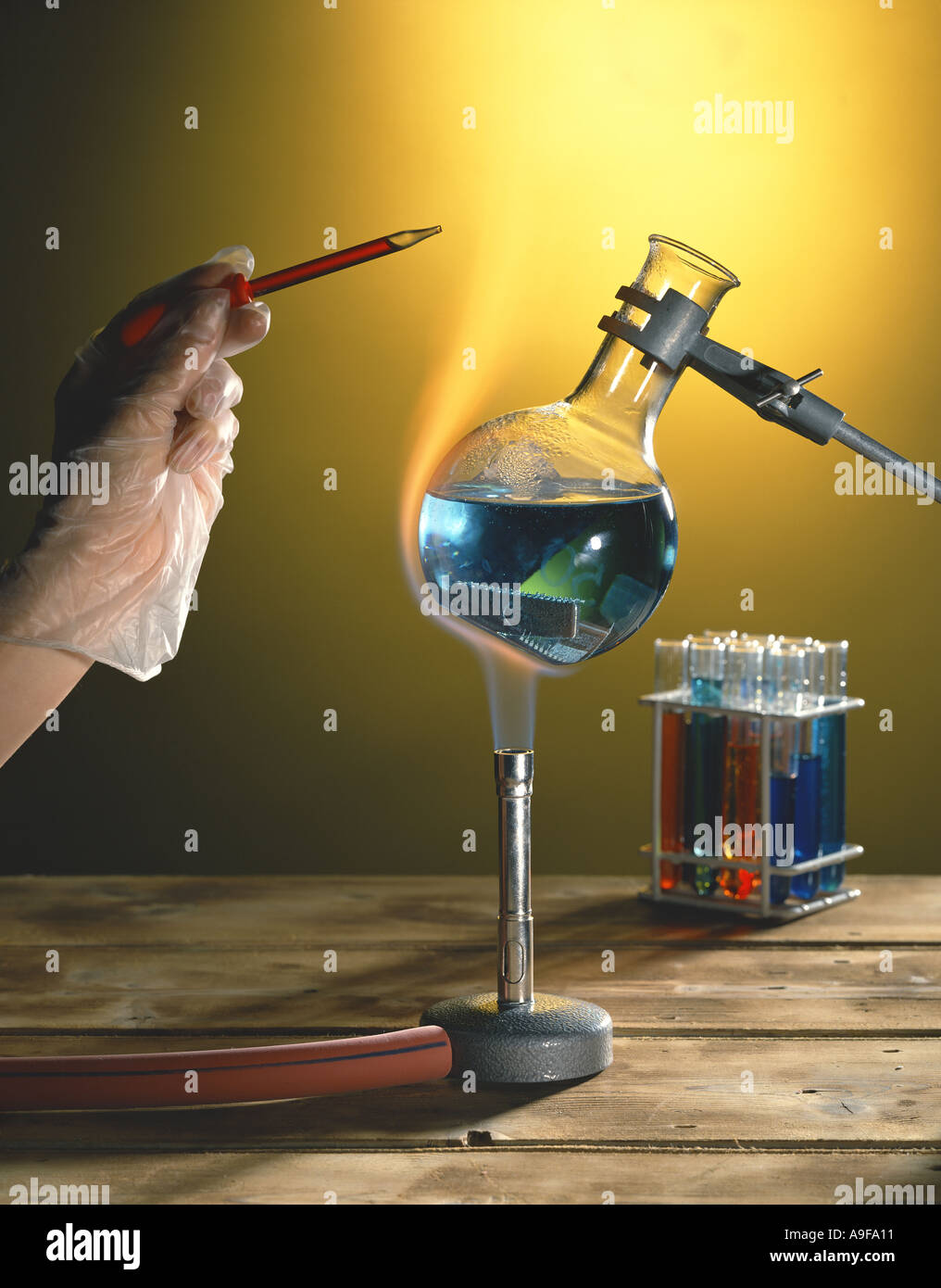 Chemie. Bunsenbrenner erhitzen Flüssigkeit mit Hand und pipette Stockfoto