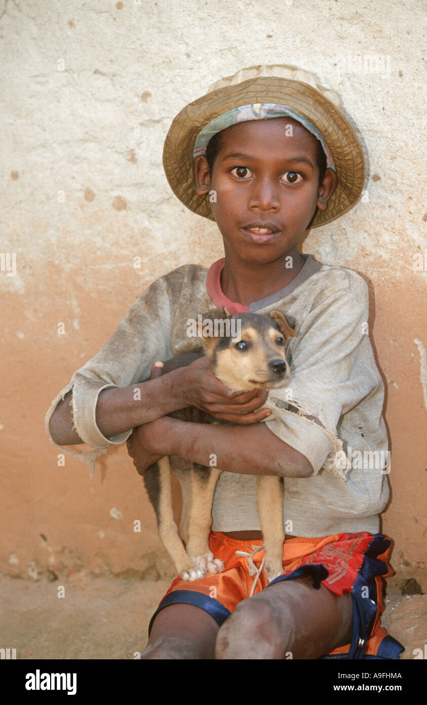 kleiner Junge Holding Hund in Armen, Madagaskar Stockfoto
