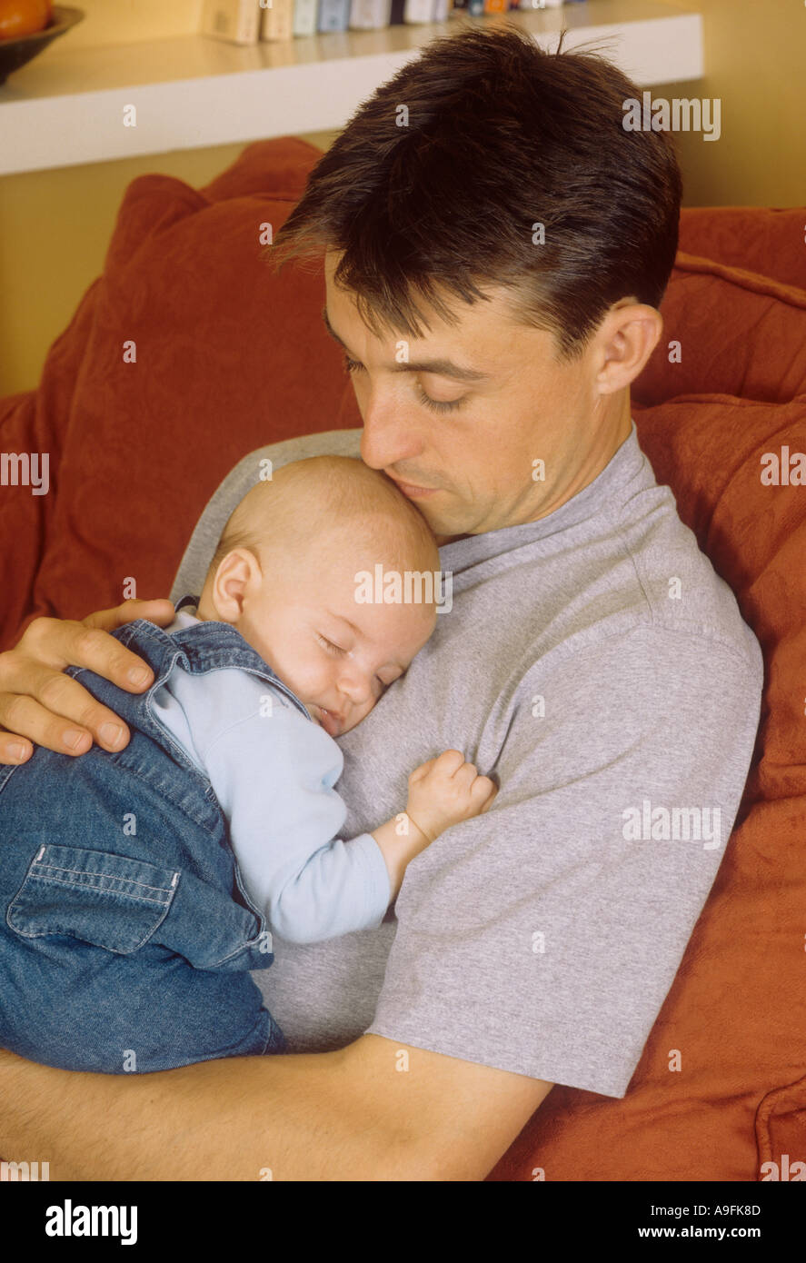 Vater verbringt Zeit mit seinem schlafenden Sohn, Großbritannien Stockfoto