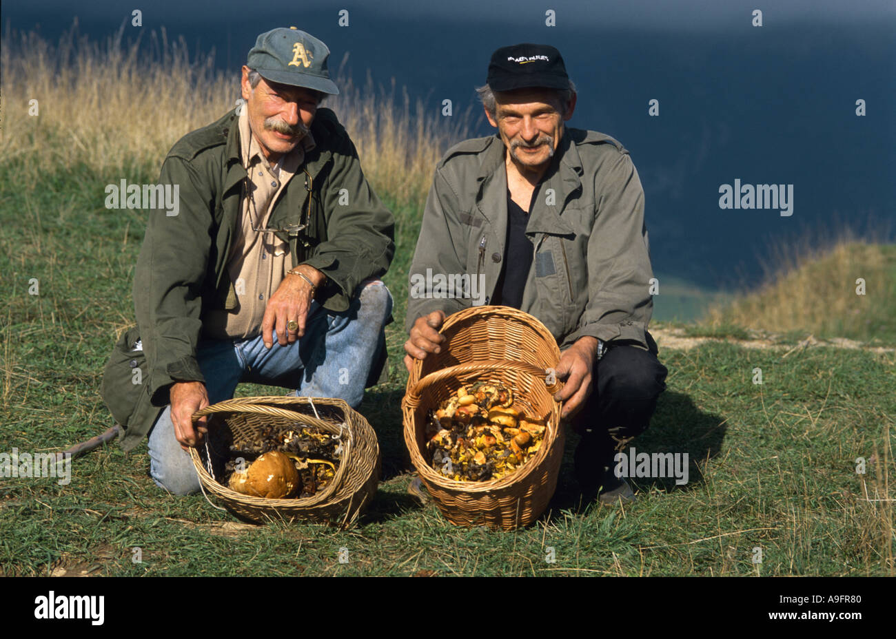 zwei Pilz Jäger präsentiert gesammelten Pilze in Weidenkörben. Stockfoto