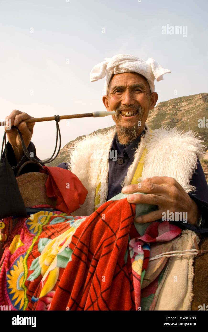 Shanxi-Bauern mit Pfeife und bunten Esel Sattel am Hukou Wasserfall am gelben Fluss (Huang He) Stockfoto