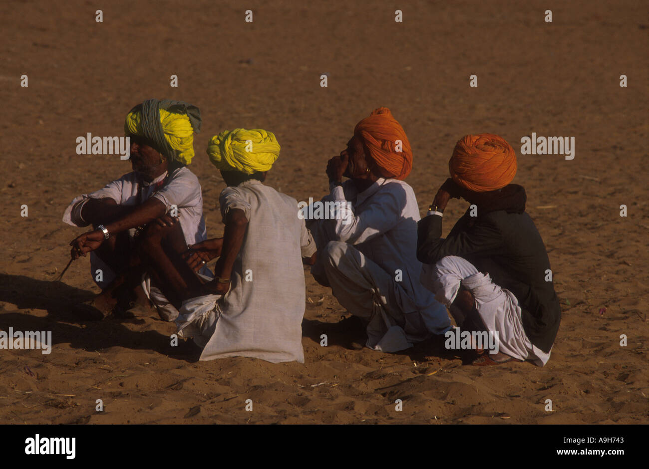 Indien Menschen Männer hocken auf Sand Pushkar Rajasthan Nordindien Stockfoto