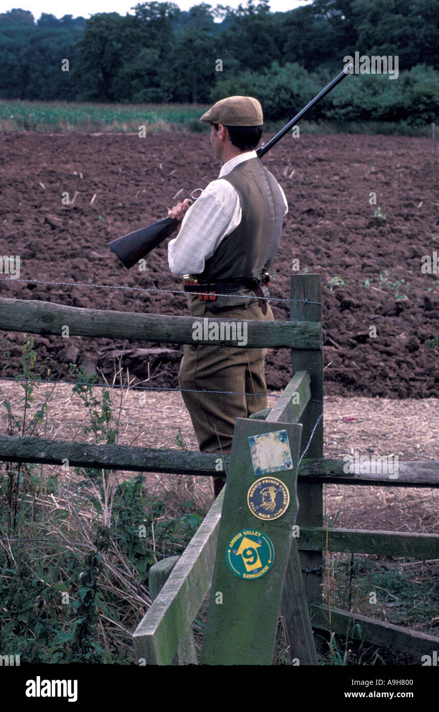 Mann mit einem Gewehr stehen Jagd, so dass er nicht über Wanderweg schießen Stockfoto