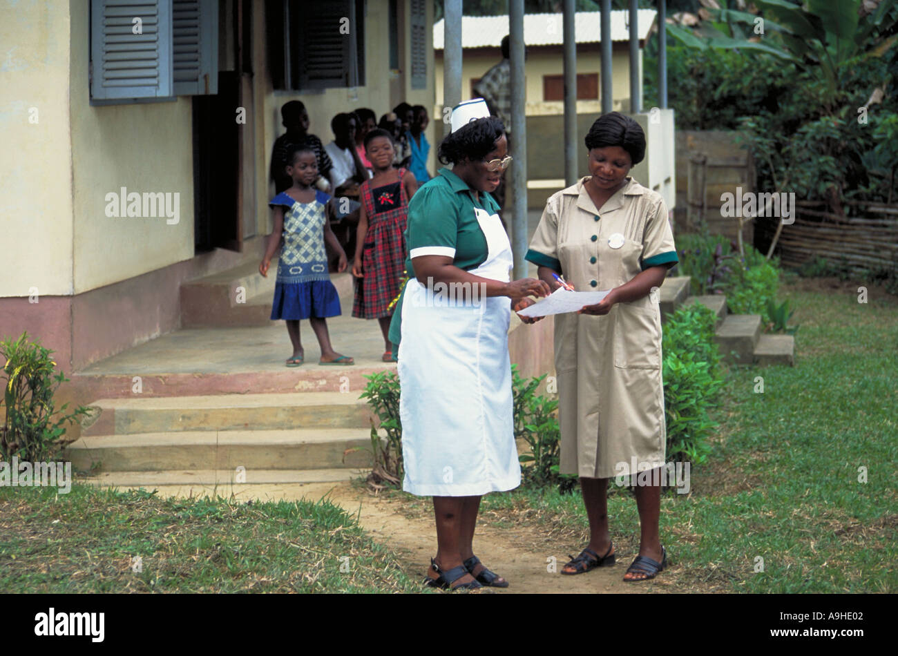 Krankenschwester und Administrator diskutieren Patientenliste außerhalb Teberebie Dorf Gesundheit Klinik in westlichen Ghana Stockfoto