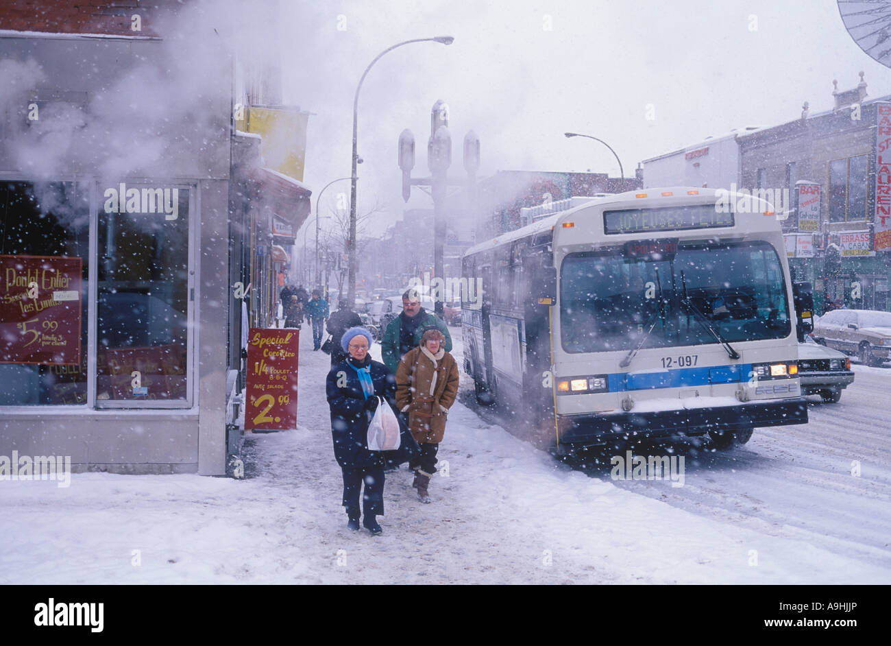 Pendler mit öffentlichen Verkehrsmitteln ankommen an ihrem Zielort, wie der Schnee um sie herum fällt. Stockfoto