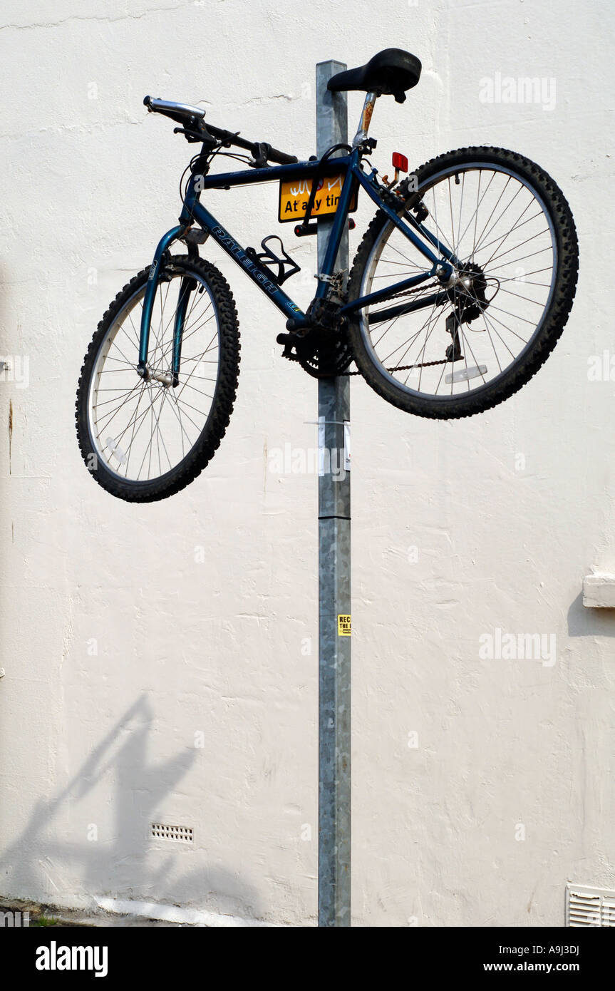 Ein Mountainbike von Raleigh wird auf Parkplatz Einschränkung Masten auf einer Straße der Stadt gesichert. Stockfoto