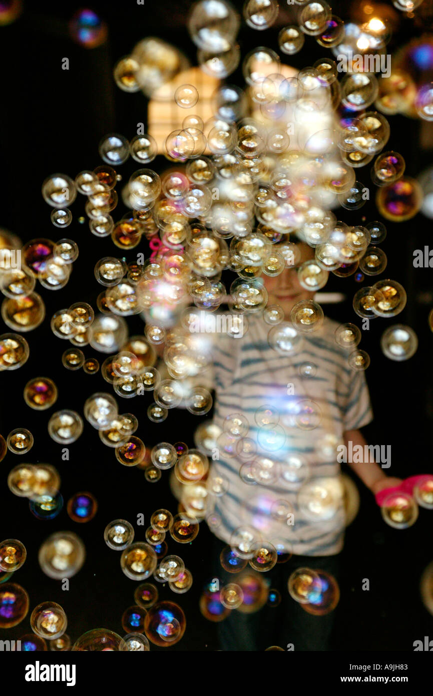 ein Junge, umgeben von Seifenblasen Stockfoto