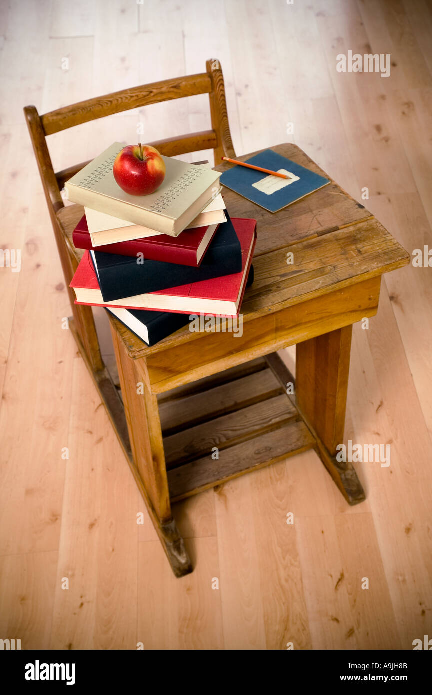 eine Schulbank mit Apfel und einige Bücher über ihn Stockfoto