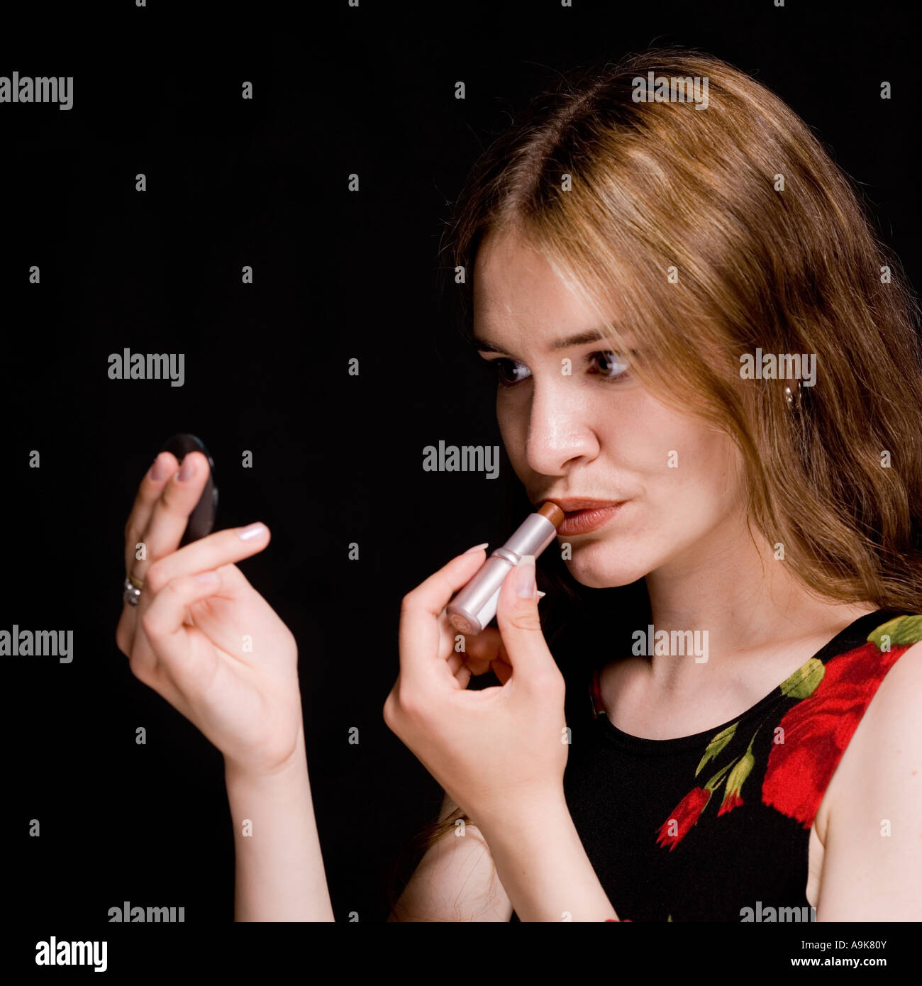 Attraktive junge Frau Auftragen von Lippenstift Stockfoto