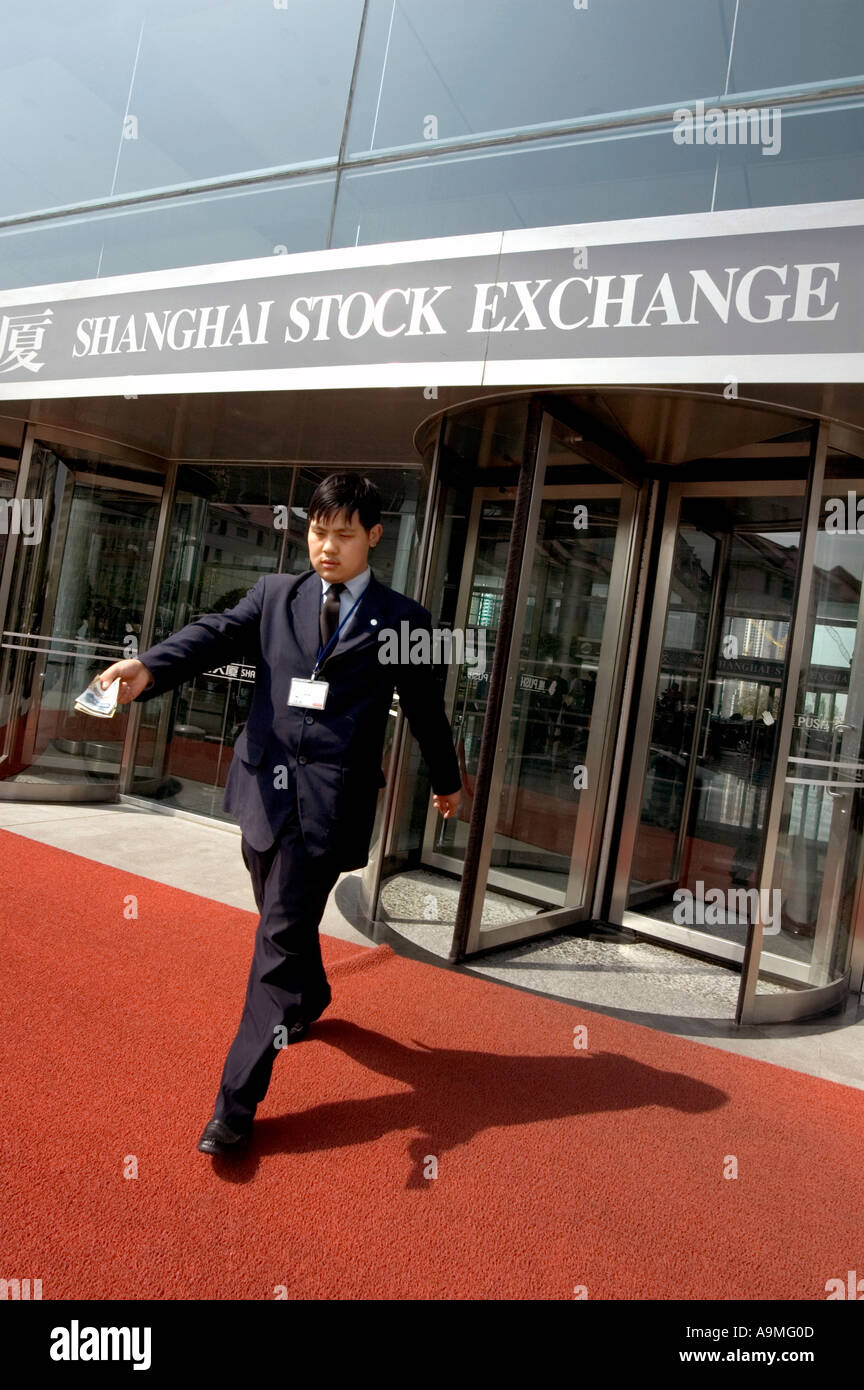 MANN VERLASSEN SHANGHAI BÖRSE MIT BARGELD IN DER HAND PUDONG SHANGHAI CHINA Stockfoto