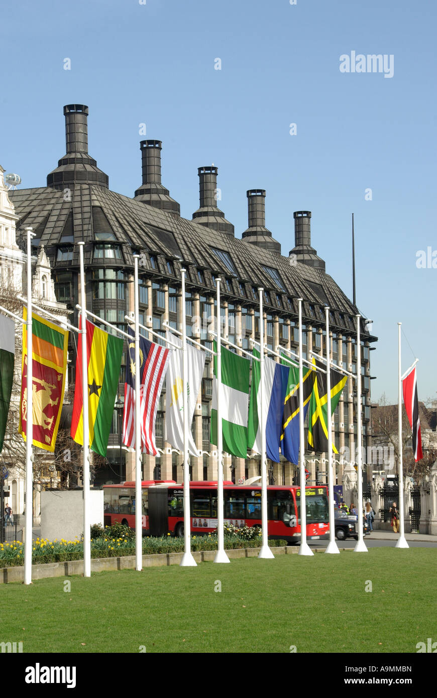 Frühling Blick auf einigen britischen Commonwealth Länder Flaggen im Parlament Platz mit Portcullis House über Westminster London England Großbritannien Stockfoto