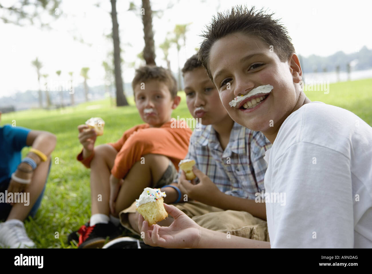 Jungen, die Cupcakes zu essen, in einem park Stockfoto