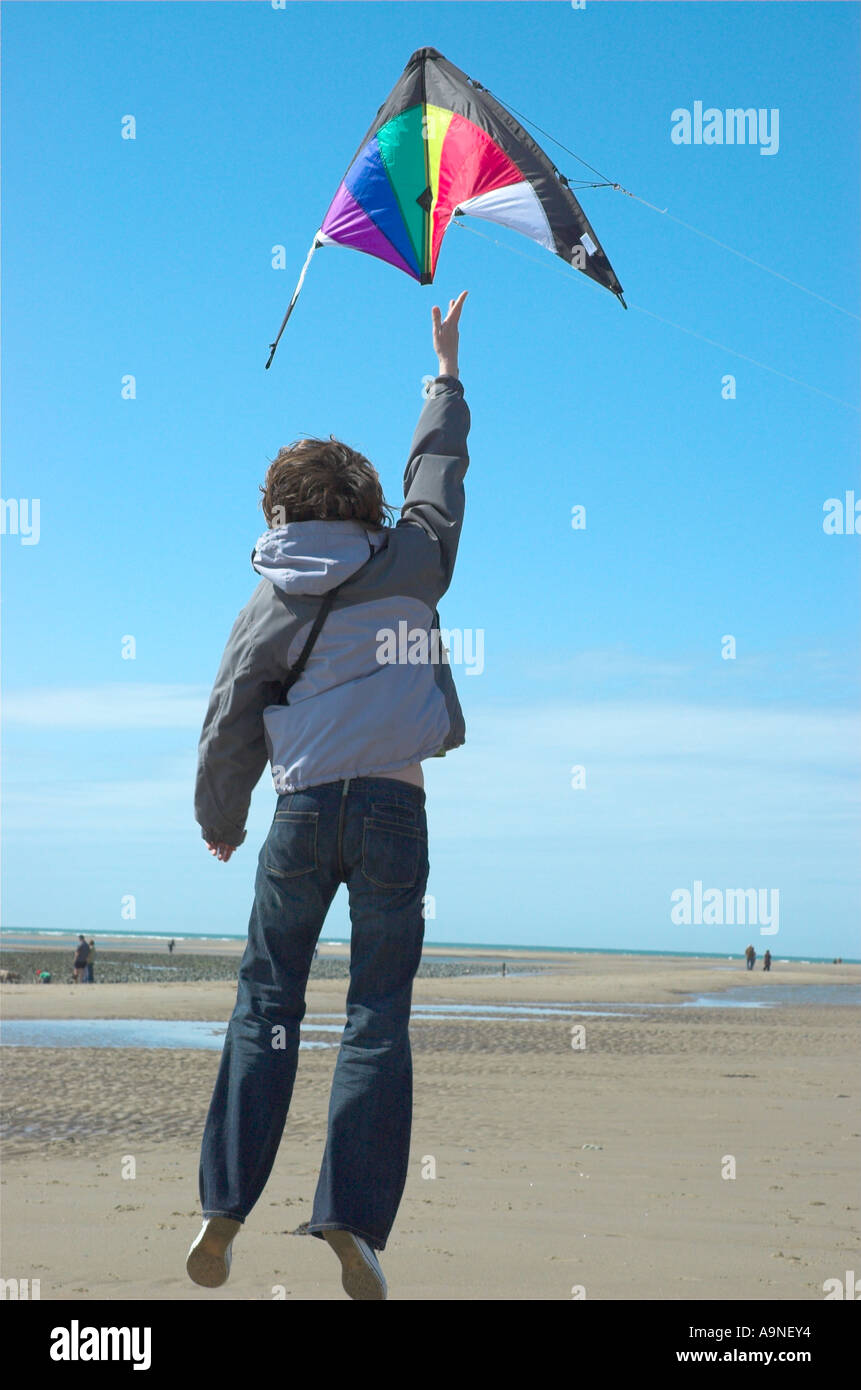 Frau startet einen Kite am Strand Stockfoto